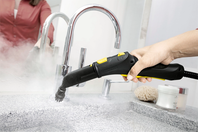 Steam brush cleaning a sink surface